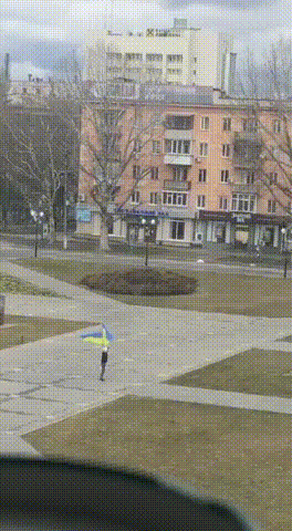 한 우크라이나인이 지난 2일(한국시각) 헤르손 중앙 광장에 입성한 러시아군을 앞에 두고 우크라이나 국기 두개를 휘날리고 있다./영상제공=재한 우크라이나인 김올레씨