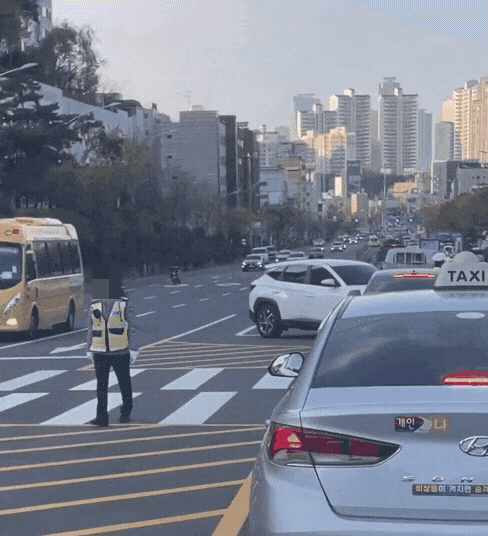 약 2년 전 서울 동작구의 한 도로에서 찍힌 것으로 알려진 영상. 영상에는 혼잡한 도로에서 교통정리를 하는 남녀 교통경찰의 모습이 담겼다. 이때 여성 경찰을 뒷짐을 지고 있어 "아무것도 하지 않은 것 아니냐"는 비판에 휩싸였다. /영상=온라인 커뮤니티