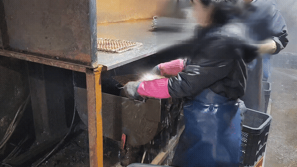 고무장갑과 앞치마를 착용한 공장 직원이 모터 기계에 불판을 닦고 있다. /영상=김미루 기자