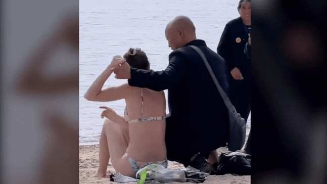 홍콩의 한 해변에서 중년의 중국 남성 관광객 3명이 비키니를 입고 있는 백인 여성에게 다가가 강제로 스킨십하며 사진을 찍는 모습./영상=틱톡