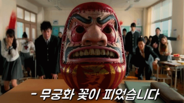 일본 데스게임 장르 영화 '신이 말하는 대로'의 한 장면. 첫 게임으로 괴상한 인형과 무궁화 꽃이 피었습니다 게임을 펼치는 모습이 오징어 게임과 유사하다. /사진=네이버영화