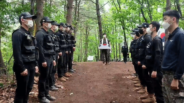 지난 16일 경기 포천시 소흘읍 무명 350고지에서 육군 8기동사단 진호대대 장병들과 국방부 유해발굴단 발굴팀이 이날 수습한 유해를 향해 도열해 경례하고 있다./영상=정세진 기자