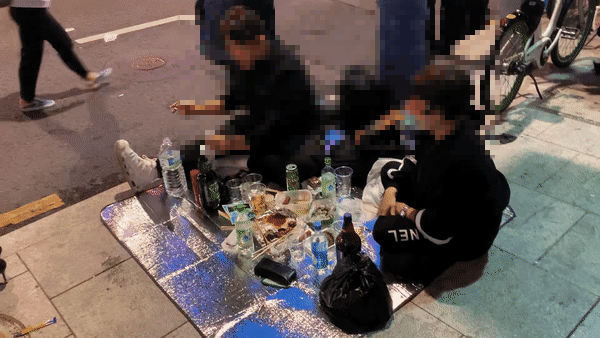 29일 밤, 이태원역 삼거리 도로 인근에서 시민들이 돗자리를 펴놓고 술을 마시고 있다. /사진=김도엽 기자