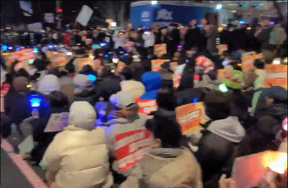 9일 국회 앞 촛불집회 현장에서 아모르파티가 흘러나오자 각자 손에 든 응원봉과 피켓을 박자에 맞춰 흔들고 있다. 추운 날씨에도 흔들다 못해 덥다며 손부채질을 하는 참가자도 있었다./영상=이찬종 기자