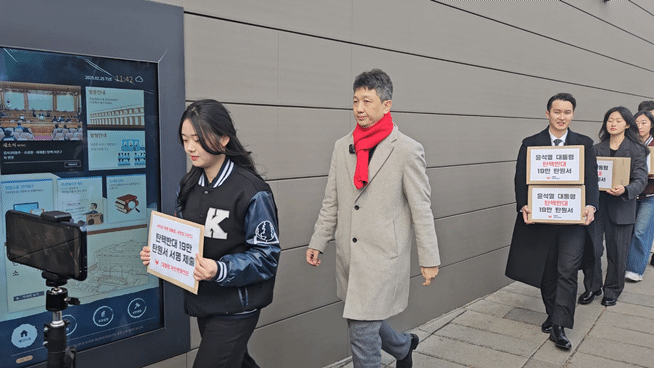 25일 오전 11시50분쯤 서울대, 연세대, 고려대, 경북대 등 대학생들로 구성된 대통령 국민변호인단이 '19만 탄핵반대 탄원서'를 헌법재판소 민원실로 들고 가는 모습/사진=박상혁 기자