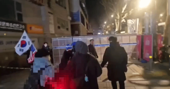 지난 29일 오후 헌법재판소 인근에서 한 탄핵 찬성 집회 참가자가 태극기와 성조기를 든 탄핵 반대 집회 참가자를 뒤에서 밀었다. /사진=X(옛 트위터) 갈무리.