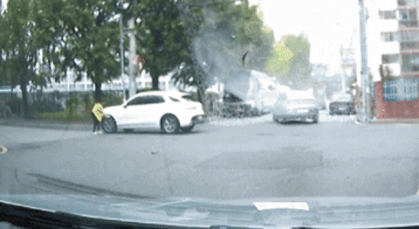 도로 한복판에서 차량에 술을 뿌리고 북어를 집어 던지는 등 고사를 지내는 듯한 행동을 한 여성 모습이 포착됐다./영상=온라인 커뮤니티 '보배드림'