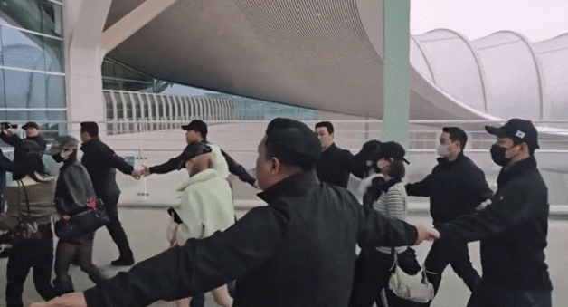 인천국제공항에서 경호 업체로부터 원형 띠 경호를 받는 그룹 하츠투하츠. 온라인 커뮤니티 캡처 