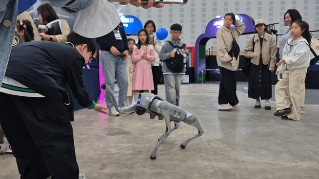아이들에게 다가가 한 손을 '척' 내밀며 애교를 부리는 영인모빌리티의 4족 보행 로봇. 낮선 외형에 어른 손을 꼭 잡은 채 무서워하던 아이들도 강아지 로봇이 먼저 다가오자 이내 손을 먼저 내밀었다. /사진=박건희 기자