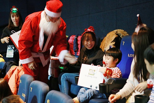 효성이 지난 15일 진행한 장애아동과의 단체 영화관람 행사에서 산타 복장을 한 효성나눔봉사단원이 아동들에게 선물을 나누어 주고 있다. /사진=효성