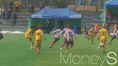 광주FC U-12팀(노란 유니폼)이 8강에서 청남초와 공을 차지하려 경합하고 있다.