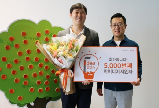 서울 중구 순화동 오렌지센터에서 5000번째 아이디어를 제안한 오렌지라이프 직원과 정문국 사장이 기념촬영을 하고 있다./사진=오렌지라이프 제공