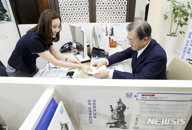 문재인 대통령이 '필승코리아 펀드' 수익금과 신규 투자액을 합산해 총 5000만원을 한국판 뉴딜 펀드에 투자한다. 사진은 문 대통령이 2019년 서울 중구 NH농협은행 본점에서 '필승코리아 펀드' 통장을 살펴보는 모습. /사진=뉴시스