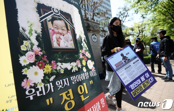 16개월 여아 '정인이'를 학대해 숨지게 한 혐의로 기소된 양부모에 대한 1심 결심공판이 열린 14일 오후 서울 양천구 남부지법 앞에 정인양의 생전 사진이 걸려 있다. 2021.4.14/뉴스1 © News1 오대일 기자