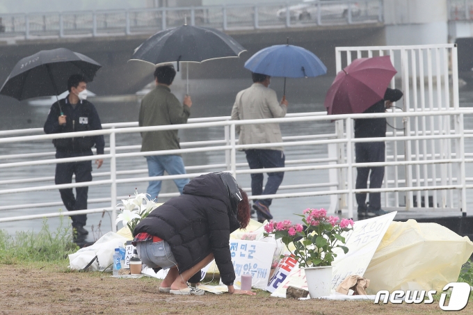 17일 오전 서울 서초구 반포한강공원 수상택시 승강장 인근에서 한 시민이 고 손정민씨를 추모하고 있다. 경찰은 이날 정민씨의 친구 A씨의 스마트폰 수색 작업을 진행했다. 2021.5.17/뉴스1 © News1 임세영 기자