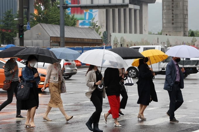 이달 들어 한달의 반이 넘는 기간동안 비가 내리고 있어 올해 국내 장마시기에 대한 관심이 높아졌다. 사진은 27일 오전 서울 종로구 광화문 네거리에서 시민들이 우산을 쓴 채 출근하는 모습. /사진=뉴스1
