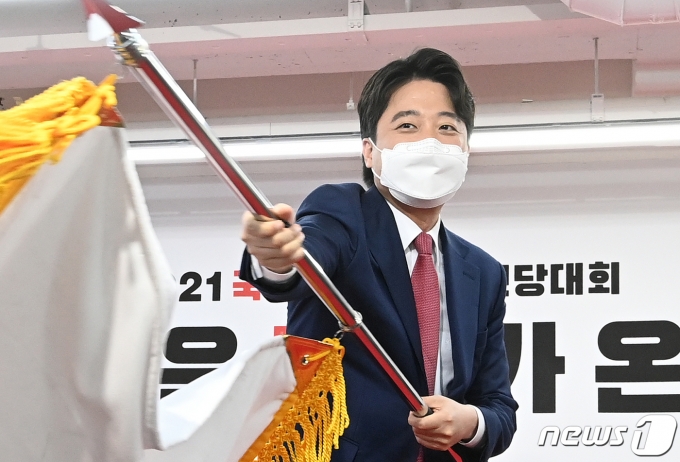 이준석 국민의힘 신임 대표가 11일 서울 여의도 국민의힘 당사에서 열린 전당대회에서 당선 확정 후 당기를 흔들고 있다./사진=뉴스1