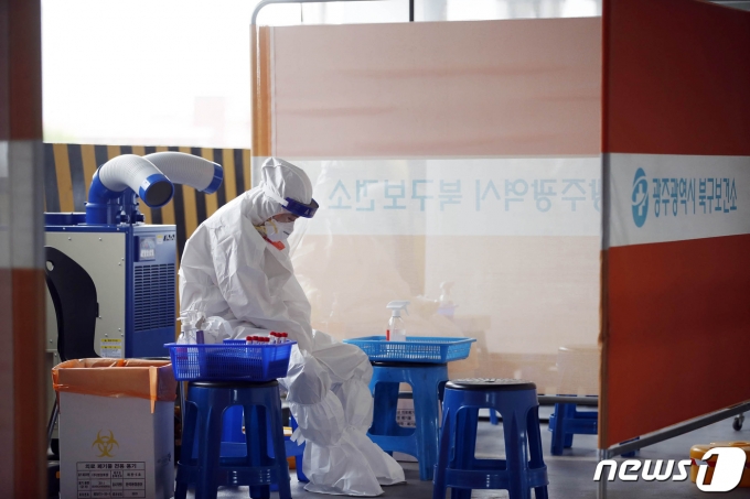 전날 내린 비가 그쳐 후텁지근한 날씨를 보인 11일 광주 북구선별진료소에서 신종 코로나바이러스 감염증(코로나19) 검사를 하는 보건소 의료진이 더위를 식히고 있다.(광주북구 제공)2021.6.11/뉴스1 © News1 허단비 기자