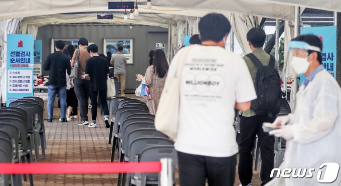 28일 서울 영등포구 여의도공원 코로나19 임시 선별진료소로 시민들이 줄이어 입장하고 있다. 2021.7.28/뉴스1 © News1 민경석 기자