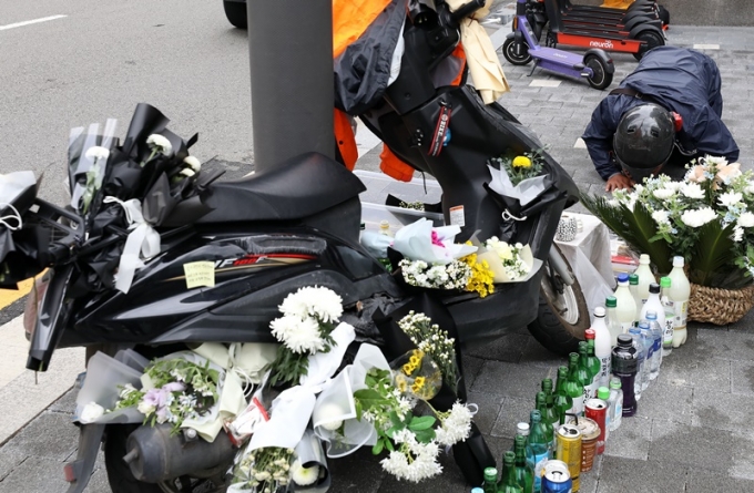 서울 강남구 선릉역 앞에서 교통사고를 당한 배달 기사를 추모하는 행사가 27일 진행됐다. 사진은 이날 선릉역 인근에 놓인 고인의 오토바이와 이를 둘러싼 조화 모습. /사진=뉴시스