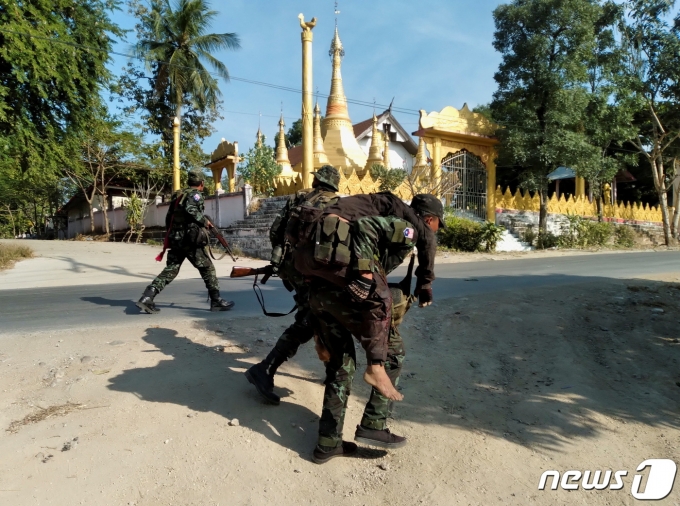 미얀마 시민방위군 전투원이 지난달 19일(현지시간) 미얀마 카인주 매 호토 탈라이 마을에서 미얀마 군부와 교전 중 부상을 입은 동료를 부축하고 있다.news1 © 로이터=뉴스1 © News1 김민수 기자