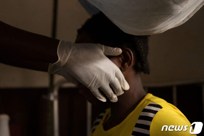 국경없는의사회 소속 한 의료인이 2018년 중앙아프리카공화국에서 원숭이두창에 걸린 여성을 진료중이다.  © AFP=뉴스1