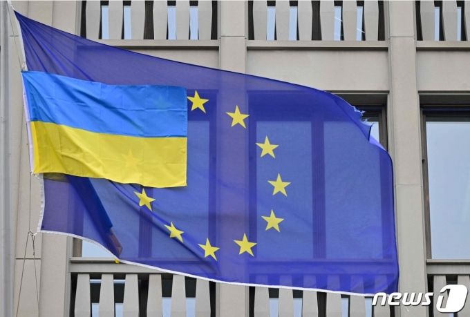 유럽연합(EU) 국기 앞에 우크라이나 국기가 게양돼 있다. © AFP=뉴스1 © News1 정윤영 기자