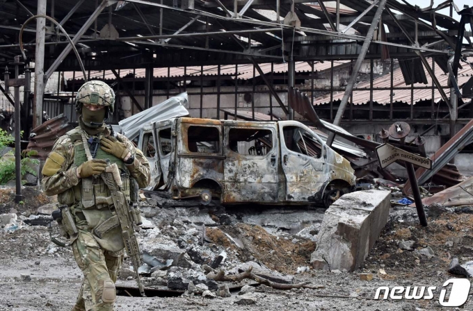 18일 (현지시간) 러시아가 점령한 마리우폴의 파괴된 일리치 제철소 주변을 병사가 순찰을 하고 있다. © AFP=뉴스1 © News1 우동명 기자
