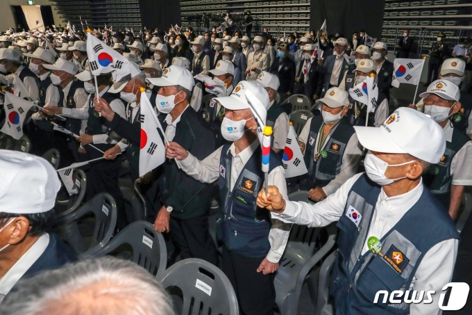 25일 오전 서울 중구 장충체육관에서 열린 '6·25 전쟁 제72주년 기념행사'에서 참전용사들이 태극기를 흔들며 '6·25의 노래'를 제창하고 있다. 2022.6.25/뉴스1 © News1 민경석 기자