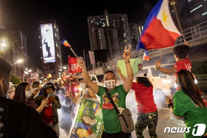 9일(현지시간) 필리핀 만달루용 거리에서 대선 초기 결과 페르디난드 봉봉 마르코스 주니어의 당선이 확실시되자 지지자들이 기뻐하는 모습. 2022. 5. 9. © 로이터=뉴스1 © News1 최서윤 기자