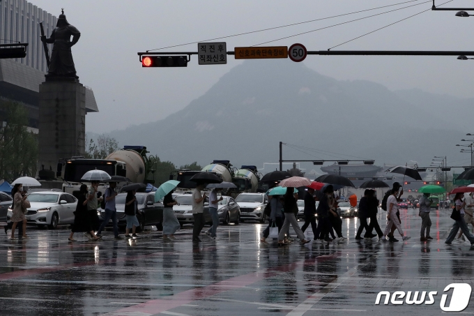 장맛비가 내리는 23일 오후 서울 시청 인근 횡단보도에서 우산을 쓴 시민들이 발걸음을 재촉하고 있다. 2022.6.23/뉴스1 © News1 박세연 기자