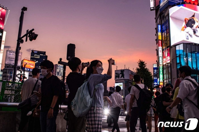 도쿄 신주쿠역 인근의 행인들이 주변을 촬영하고 있다. © AFP=뉴스1 © News1 강민경 기자