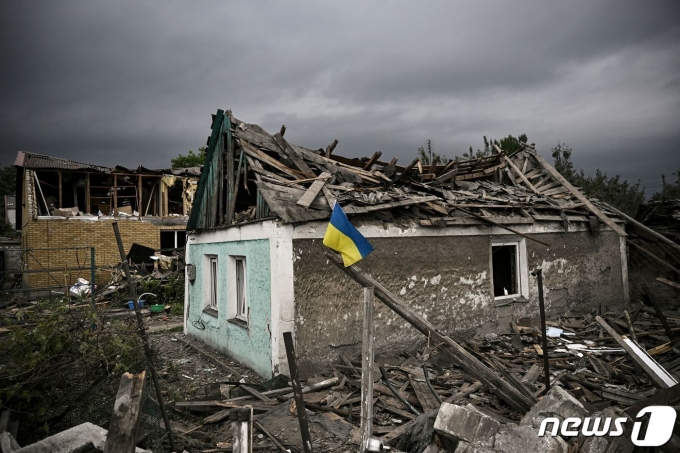 15일 (현지시간) 우크라이나 돈바스 도브로필리아에서 국기가 걸린 주택이 러시아 군의 포격을 받아 파괴된 모습이 보이고 있다. © AFP=뉴스1 © News1 우동명 기자