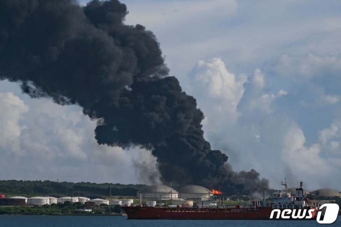 6일 (현지시간) 중남미 쿠바 마탄사스에 있는 대형 석유 저장 단지 내 원유 탱크가 벼락을 맞고 폭발해 검은 연기가 솟아오르고 있다. ⓒ AFP=뉴스1 ⓒ News1 우동명 기자