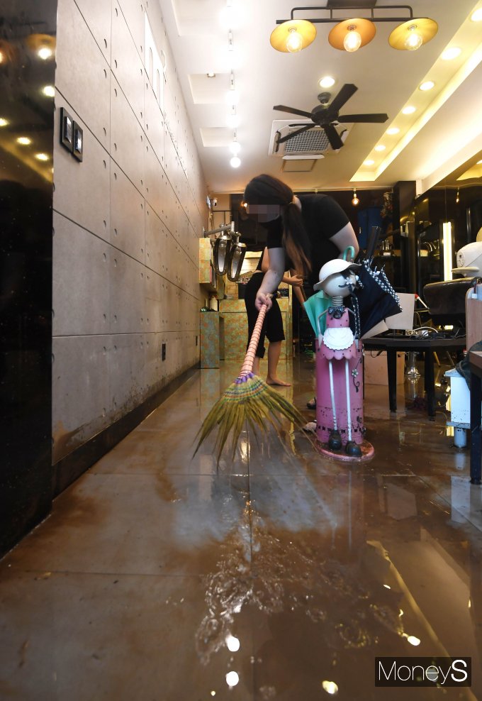 [머니S포토] 폭우로 침수된 가게 청소
