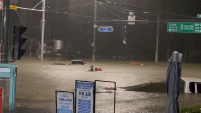 폭우로 생긴 웅덩이에 고립된 남성을 구하는 모습이 포착돼 훈훈함을 안겼다. 사진은 차량 운전자를 구조하는 남성의 모습. /사진=JTBC 갈무리