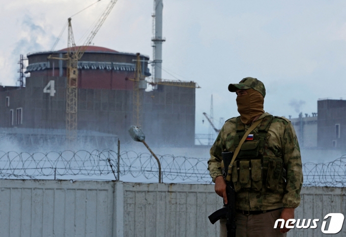 4일 우크라이나 자포리자 원자력발전소 앞을 러시아 국기가 부착된 군복을 입은 군인이 지키고 있다. ⓒ 로이터=뉴스1 ⓒ News1 강민경 기자