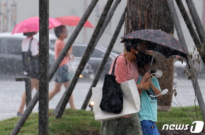 소나기가 내린 8월6일 서울 종로구 광화문 앞 삼거리도로에서 우산을 쓴 시민들이 발걸음을 옮기고 있다. 2022.8.6/뉴스1 ⓒ News1 이동해 기자