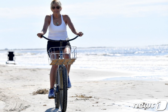 조 바이든 미국 대통령의 부인 질 바이든 여사가 14일 (현지시간) 여름 휴가지인 사우스캐롤라이나주 키아와 아일랜드 아일랜드 해변에서 자전거를 타고 있다. ⓒ AFP=뉴스1 ⓒ News1 우동명 기자
