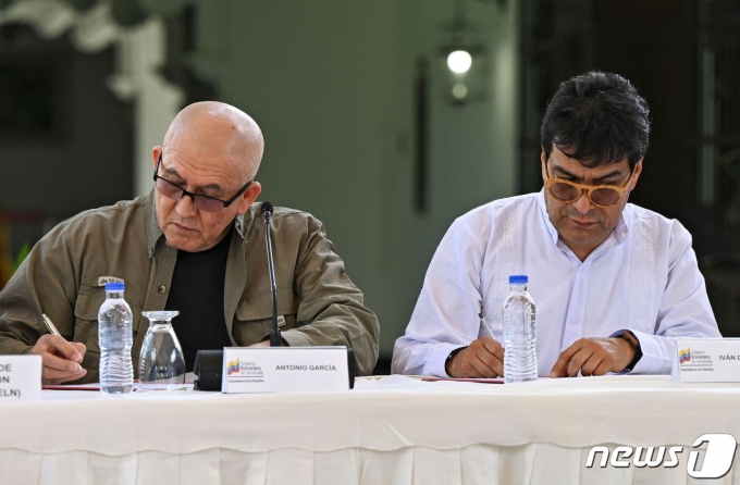 안토니오 가르시아(왼) 콜롬비아 민족해방군(ELN) 제1사령관과 다닐로 루에다 콜롬비아 정부 측 평화협상 담당관이 4일(현지시간) 베네수엘라 카라카스에서 평화협상 재개 합의서에 서명하고 있다. 2022. 10. 4. ⓒ AFP=뉴스1 ⓒ News1 최서윤 기자