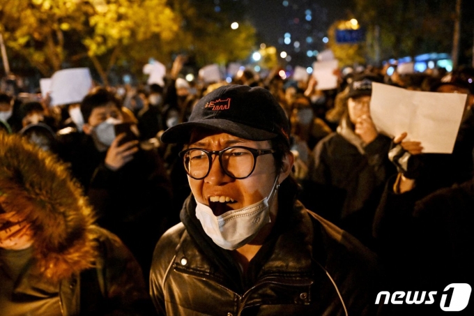 28일(현지시간) 중국 베이징에서 정부의 고강도 제로 코로나19 봉쇄 정책에 항의하고 우루무치 화재 희생자를 추모하는 주민이 “봉쇄 해제하라” “시진핑 물러나라” 는 구호를 외치며 밤샘 시위를 하고 있다. ⓒ AFP=뉴스1 ⓒ News1 우동명 기자