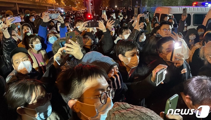 28일(현지시간) 중국 베이징에서 정부의 고강도 제로 코로나19 봉쇄 정책에 항의하고 우루무치 화재 희생자를 추모하는 주민이 “봉쇄 해제하라” “시진핑 물러나라” 는 구호를 외치며 밤샘 시위를 하고 있다. ⓒ AFP=뉴스1 ⓒ News1 우동명 기자
