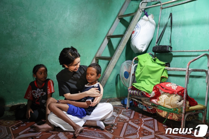 윤석열 대통령 부인 김건희 여사가 12일 캄보디아 프놈펜에서 선천성 심장질환을 앓고 있는 14세 아동의 집을 찾아 아이를 안고 있다. 대통령실에 따르면 이 아동의 어머니는 “12명의 자녀 중 가난으로 4명의 자녀를 잃었다