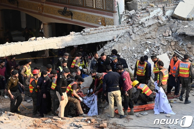 30일(현지시간) 파키스탄 페샤와르 경찰 단지 내 이슬람 사원에서 자폭 테러가 발생해 그 잔해물 속에서 구조작업이 이뤄지고 있다. ⓒ AFP=뉴스1 ⓒ News1 강민경 기자