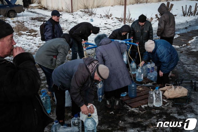 3일(현지시간) 우크라이나 동부 도네츠크주 바흐무트에서 주민들이 새로운 우물가에서 물을 기르고 있다. 2023.2.3 ⓒ AFP=뉴스1 ⓒ News1 정윤미 기자