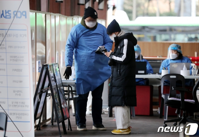 서울 송파구 보건소 선별진료소에서 한 시민이 PCR검사를 받기 위해 접수를 하고 있다./뉴스1 ⓒ News1 김진환 기자
