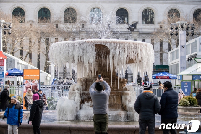 4일(현지시간) 미국 뉴욕시 브라이언트 공원 분수 앞에서 사람들이 얼어붙은 고드름을 사진에 담고 있다. ⓒ 로이터=뉴스1 ⓒ News1 권진영 기자