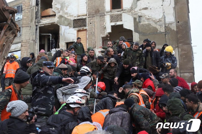 6일(현지시간) 시리아 하마에서 지진 잔해에 깔린 생존자를 구출하는 구조대원들 주위로 사람들이 구름떼처럼 모여들었다. ⓒ 로이터=뉴스1 ⓒ News1 권진영 기자