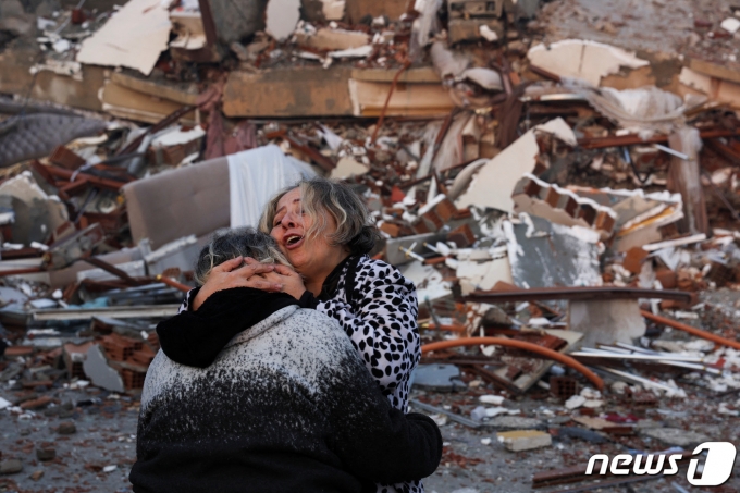 7일 튀르키예(터키) 남동부 하타이에서 강진으로 무너진 건물 앞에서 시민들이 서로 껴안으며 통곡하고 있다. ⓒ 로이터=뉴스1 ⓒ News1 박재하 기자