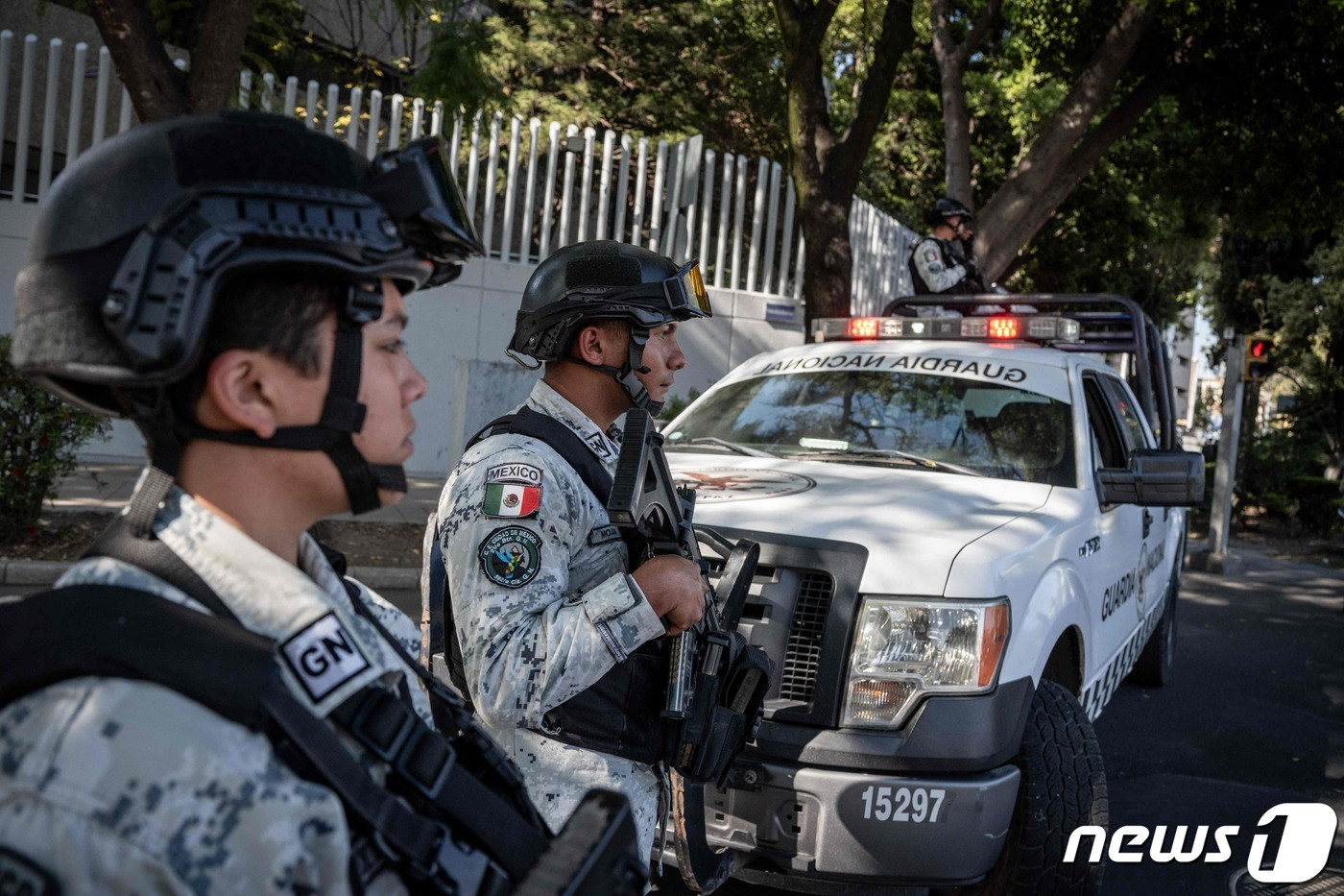 (멕시코시티 AFP=뉴스1) 김성식 기자 = 5일(현지시간) 멕시코 수도 멕시코시티에서 현지 군 당국이 멕시코 마약왕 '엘차포'의 아들 오비디오 구스만(32)을 구속한 가운데 갱단의 보복에 대비해 중무장한 군경이 멕시코 법무장관 집무실 앞에서 삼엄한 경비를 하고 있다. 2023.1.5.   ⓒ AFP=뉴스1  Copyright © 뉴스1. All rights reserved. 무단 전재 및 재배포 금지.